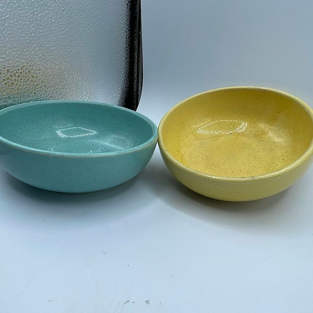 Vintage McCoy pottery bowls in speckled yellow and blue.